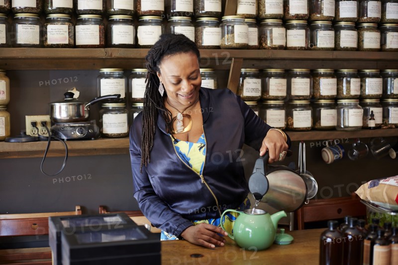 Black woman pouring tea in tea shop