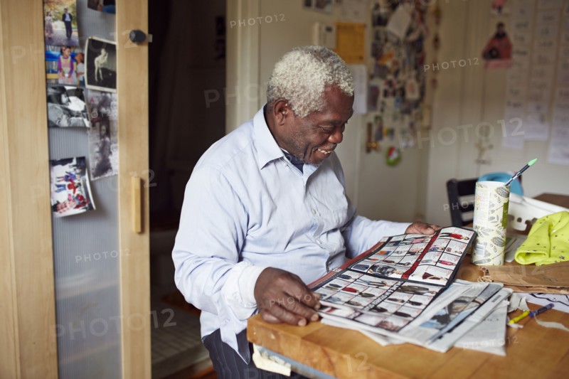 Black man reading magazine at table
