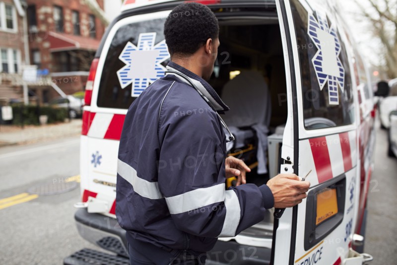Mixed race paramedic opening ambulance