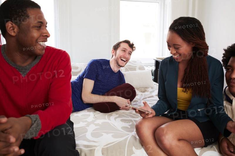 Friends relaxing in bedroom