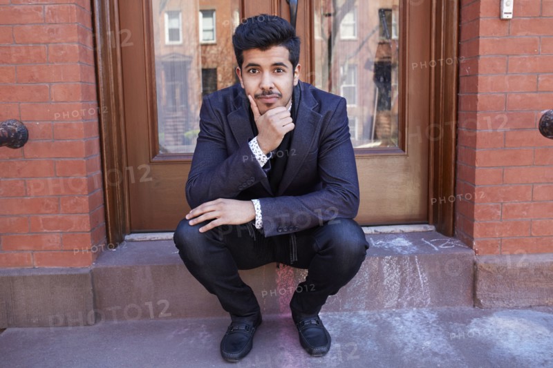 Middle Eastern man sitting on front stoop