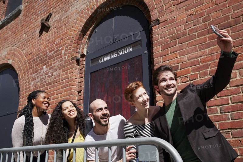 Friends posing for selfie behind railing