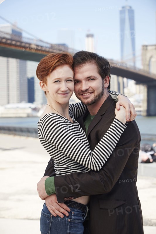 Caucasian couple hugging at waterfront
