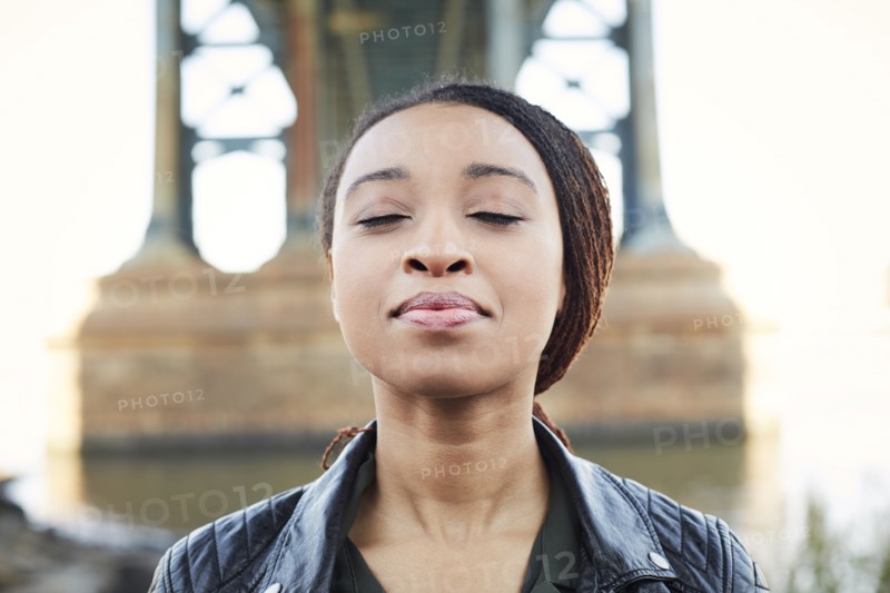 Black woman thinking with eyes closed at bridge