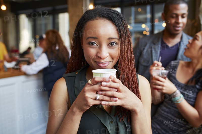 Smiling woman drinking coffee in cafe