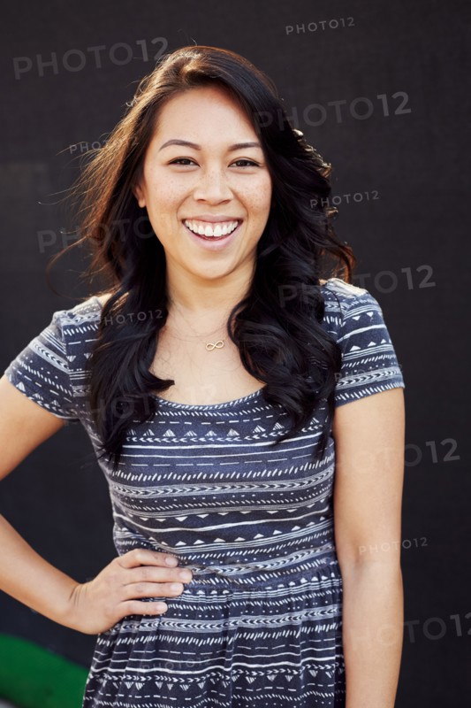 Laughing Pacific Islander woman standing with hand on hip
