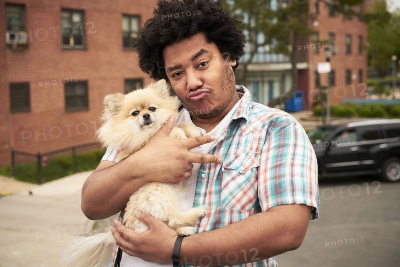 Mixed Race man gesturing peace with dog in city