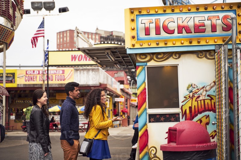 Friends waiting in line at amusement park ticket booth