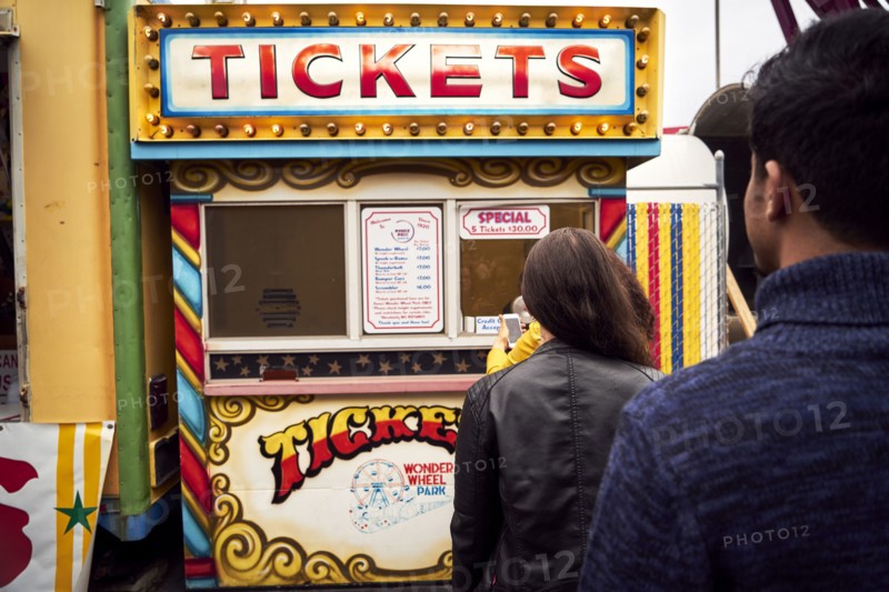 Friends waiting in line at amusement park ticket booth