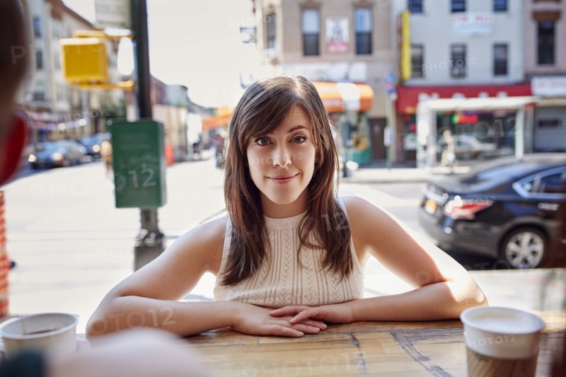 Smiling Caucasian woman leaning on counter in city