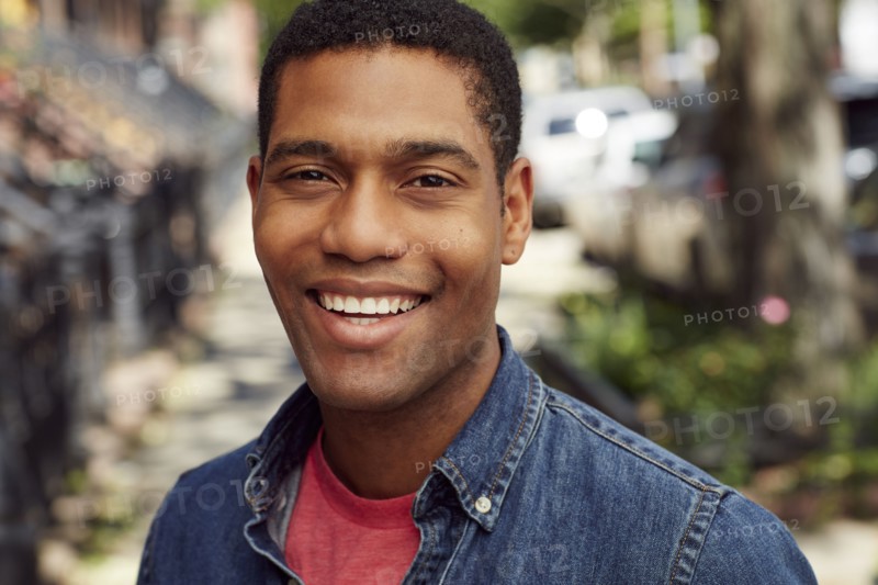 Smiling man posing on city sidewalk