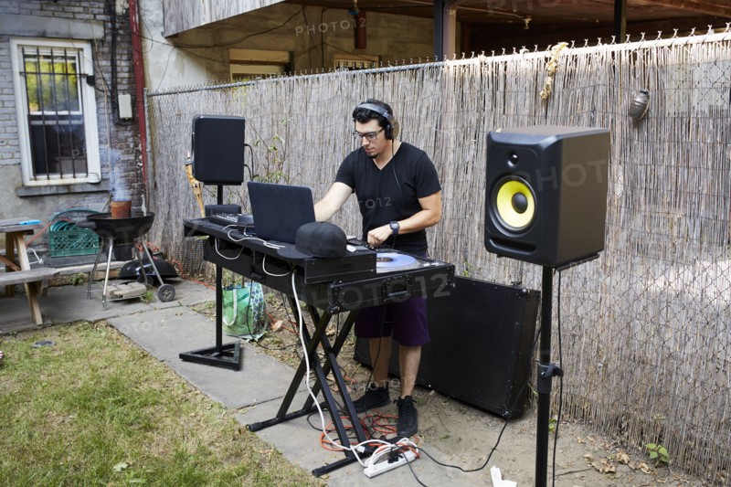 Hispanic dj playing music in backyard