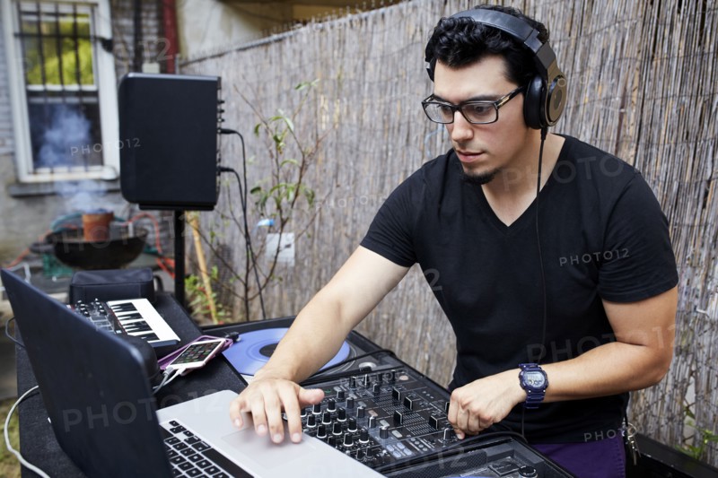 Hispanic dj playing music in backyard