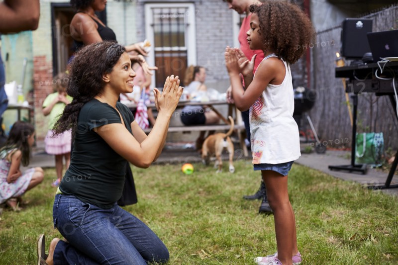 Mixed Race mother and daughter playing clapping game