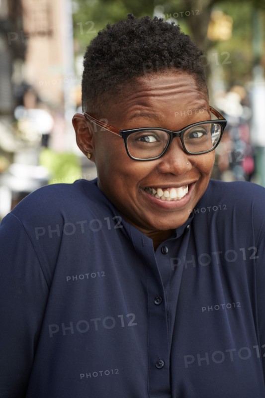 Portrait of Black woman shrugging on city sidewalk