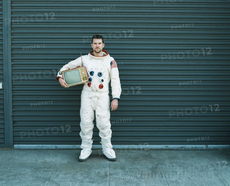 Astronaut carrying television on city street