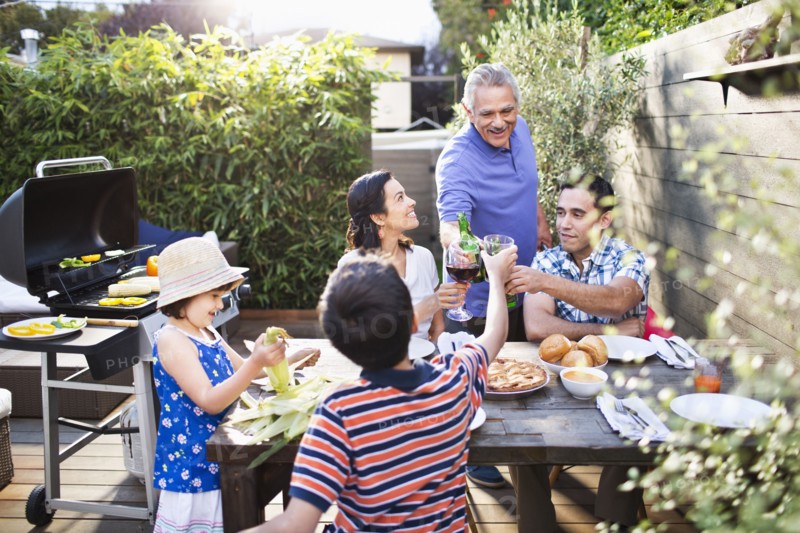 Family toasting each other at table outdoors