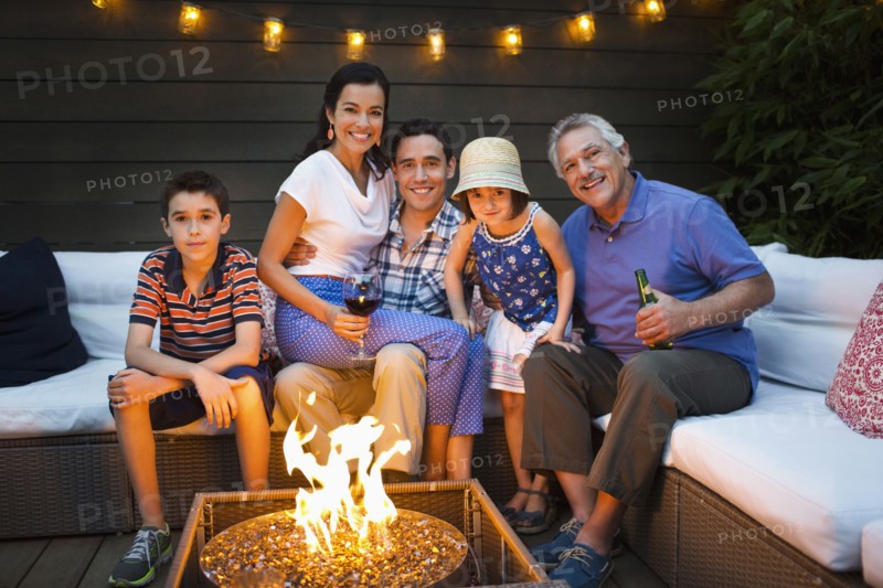 Family smiling around fire pit outdoors