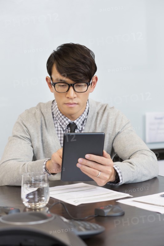 Korean businessman using digital tablet in office