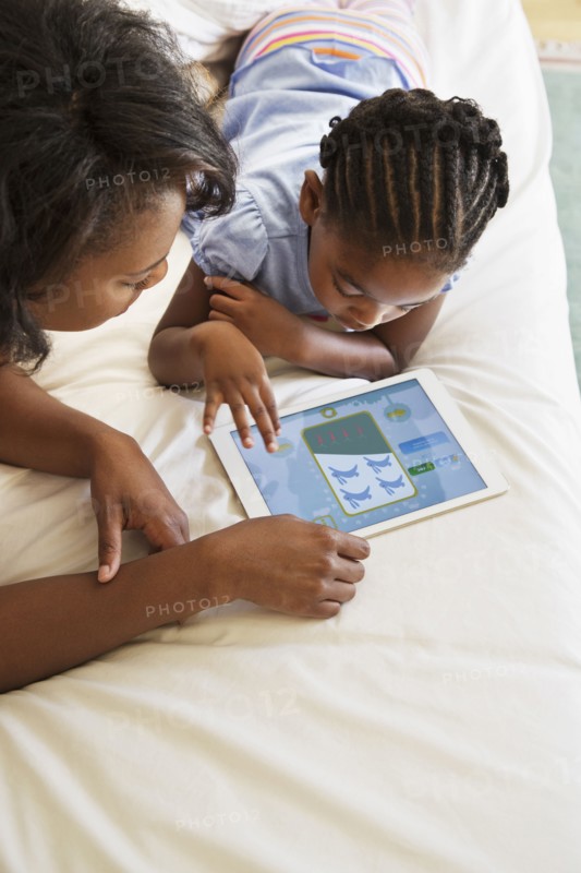African American mother and daughter using digital tablet