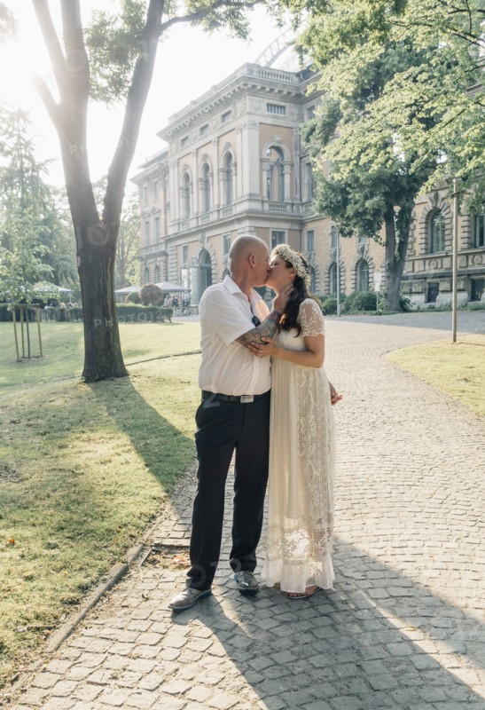 Caucasian newlywed couple kissing outdoors