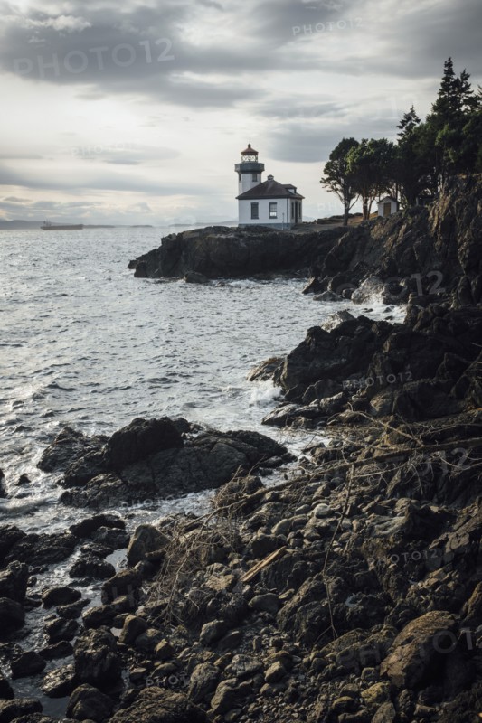 Distant lighthouse on rocky beach