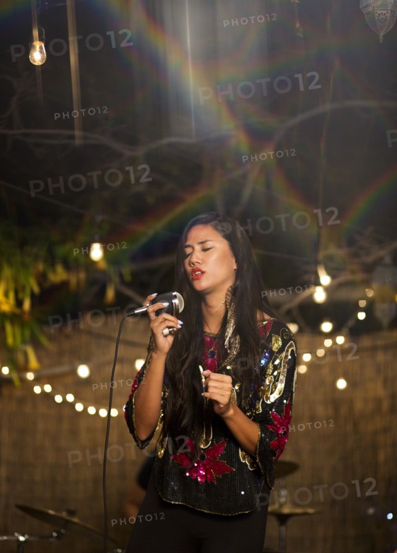 Mixed Race woman holding microphone and singing