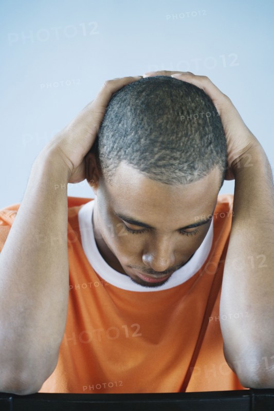 Young man holding his head in his hands