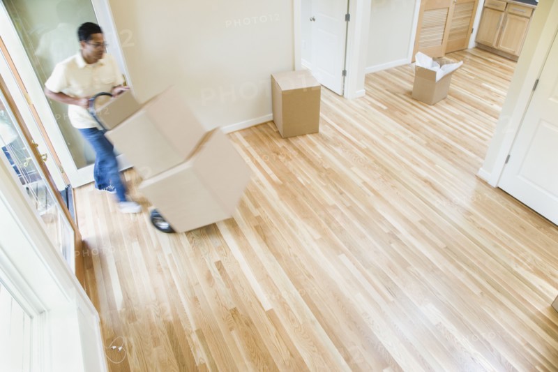 Asian man moving boxes in new house