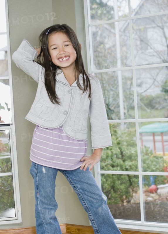 Mixed Race girl posing next to window