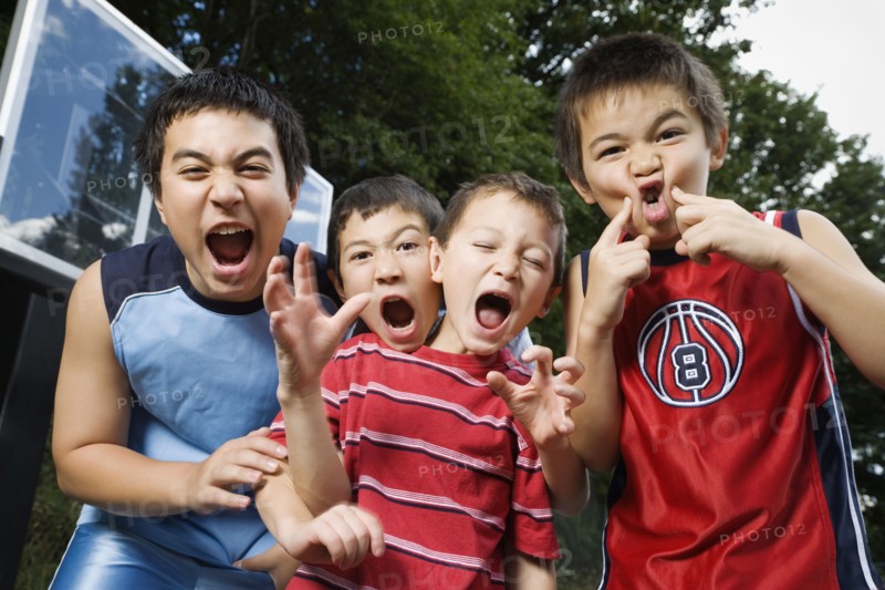 Asian brothers yelling on basketball court