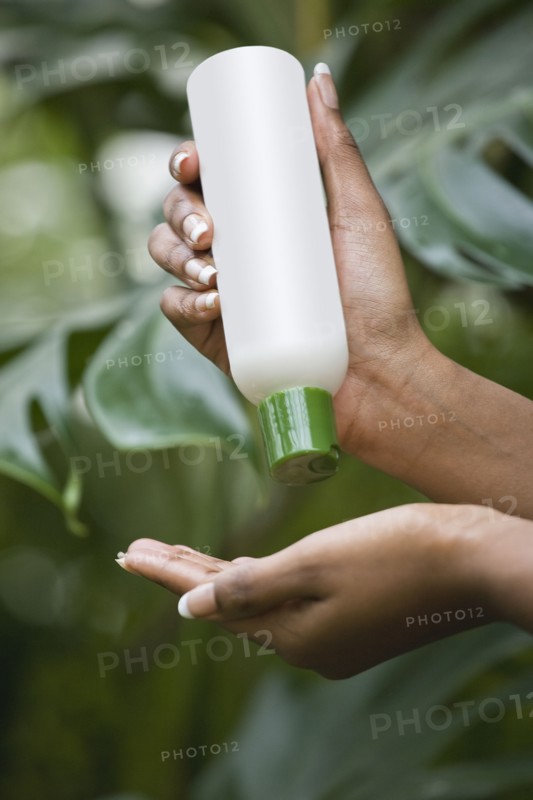 Mixed race woman pouring lotion into hand