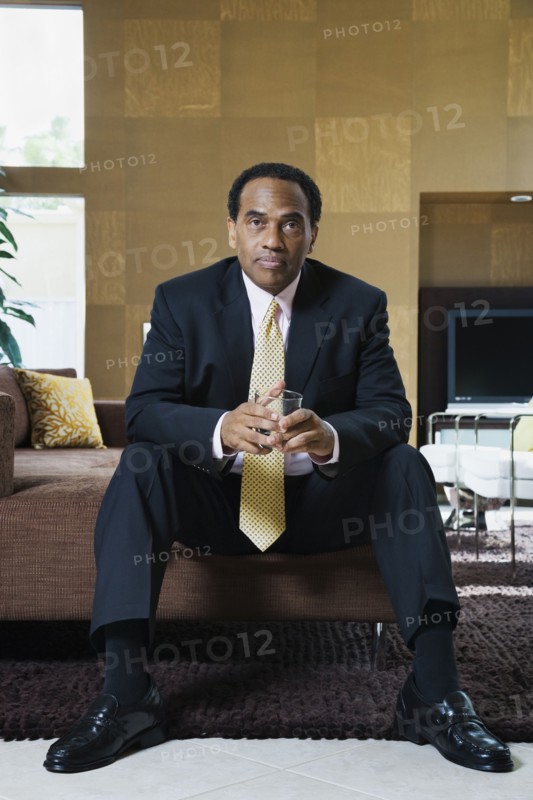 Confident African businessman sitting in modern living room