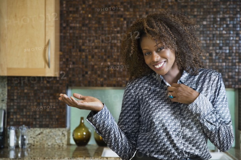 Proud African woman showing off modern kitchen