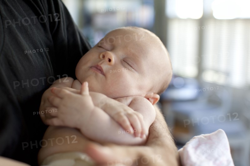 Caucasian father holding baby daughter