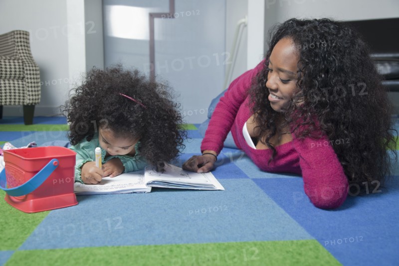 Mixed race mother watching daughter color