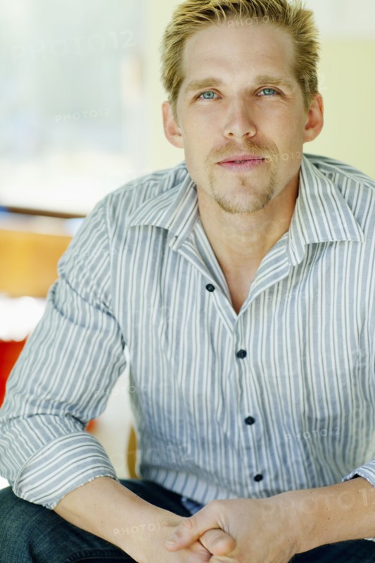 Serious Caucasian man with hands clasped