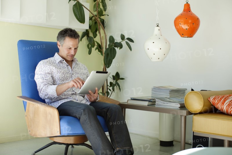 Man using digital tablet in living room
