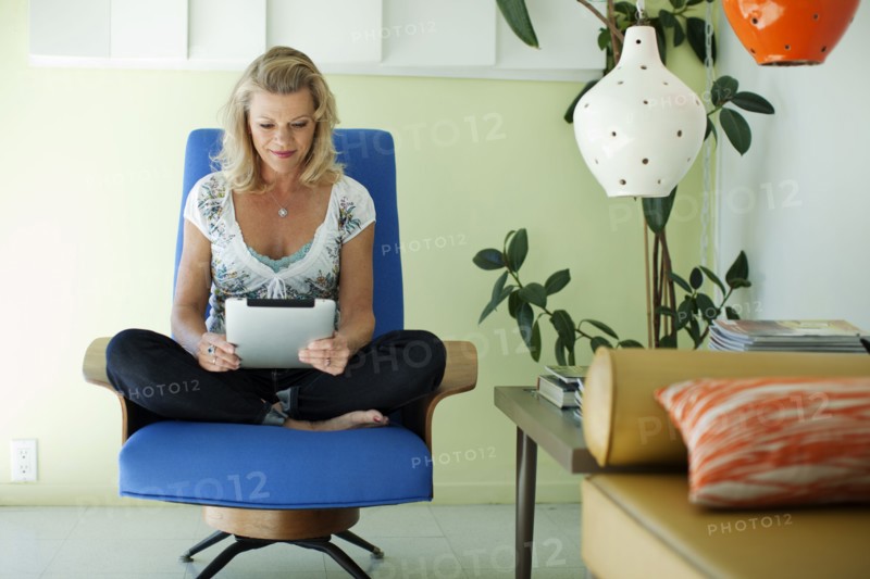 Caucasian woman using digital tablet in living room