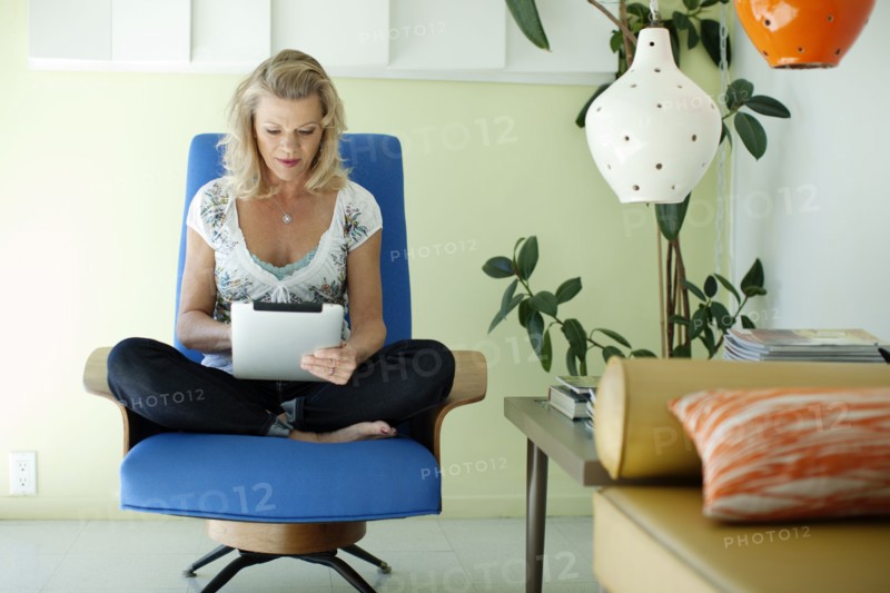 Caucasian woman using digital tablet in living room