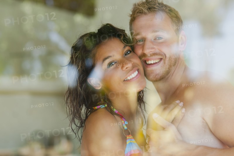 Couple hugging behind window