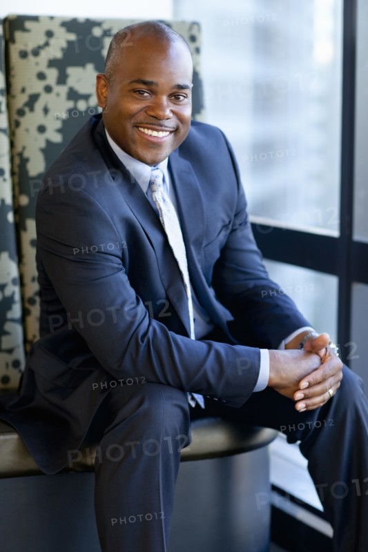 Smiling African American businessman sitting in office lobby