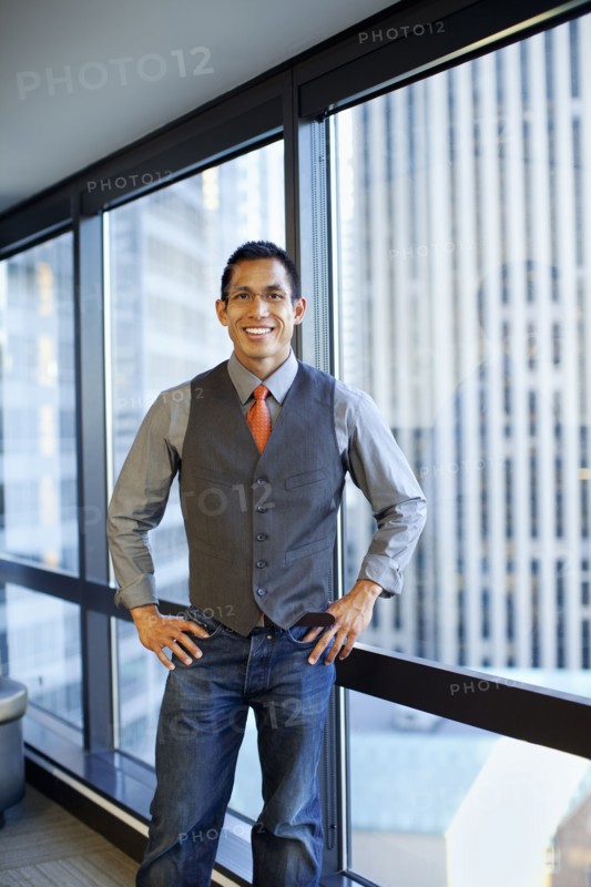 Smiling mixed race businessman standing in office