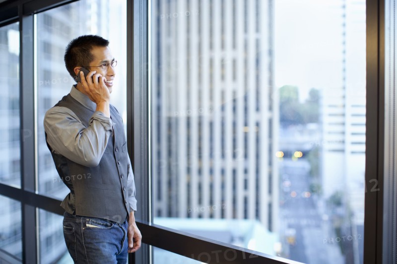Mixed race businessman using cell phone in office