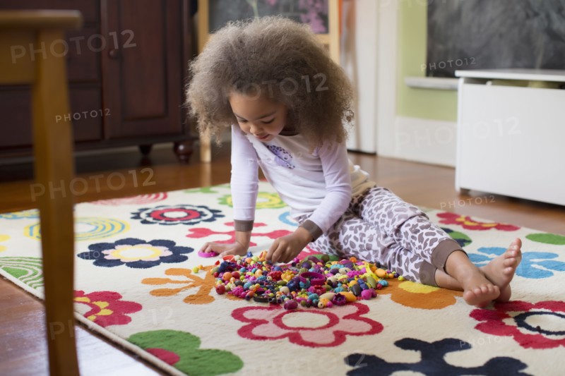 Mixed race girl playing with toys on floor