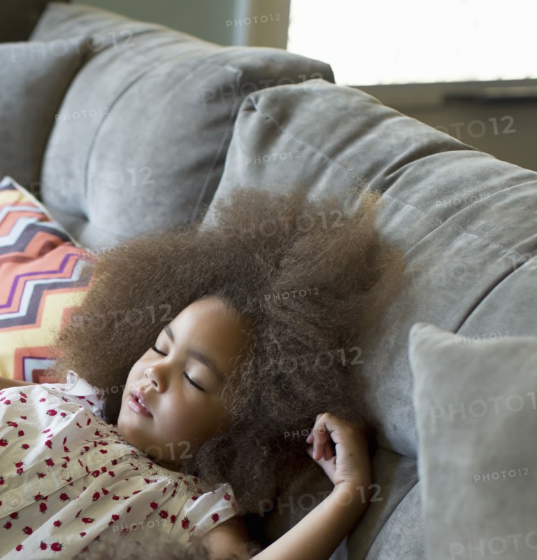 Mixed race girl sleeping on sofa