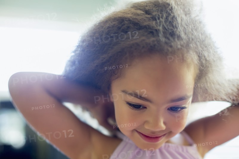 Mixed race girl tying her shirt