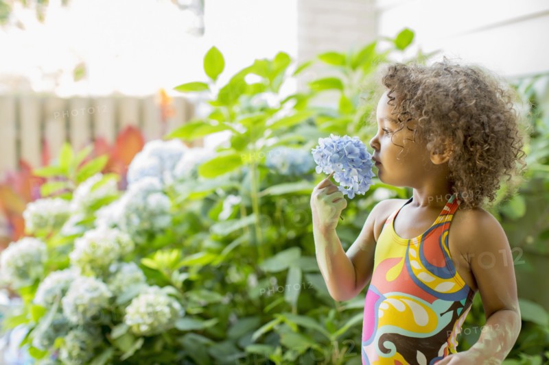 Mixed race girl smelling flower