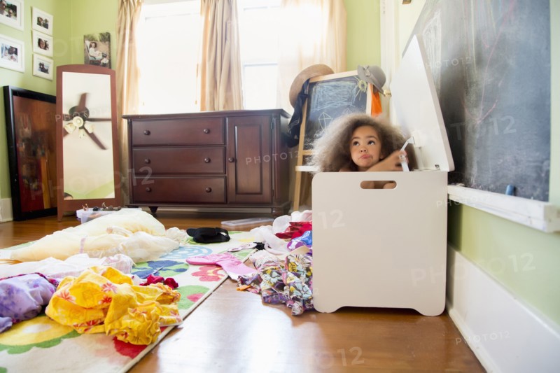Mixed race girl hiding in hamper