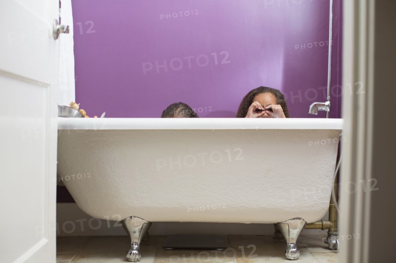 Mixed race girls playing in bathtub